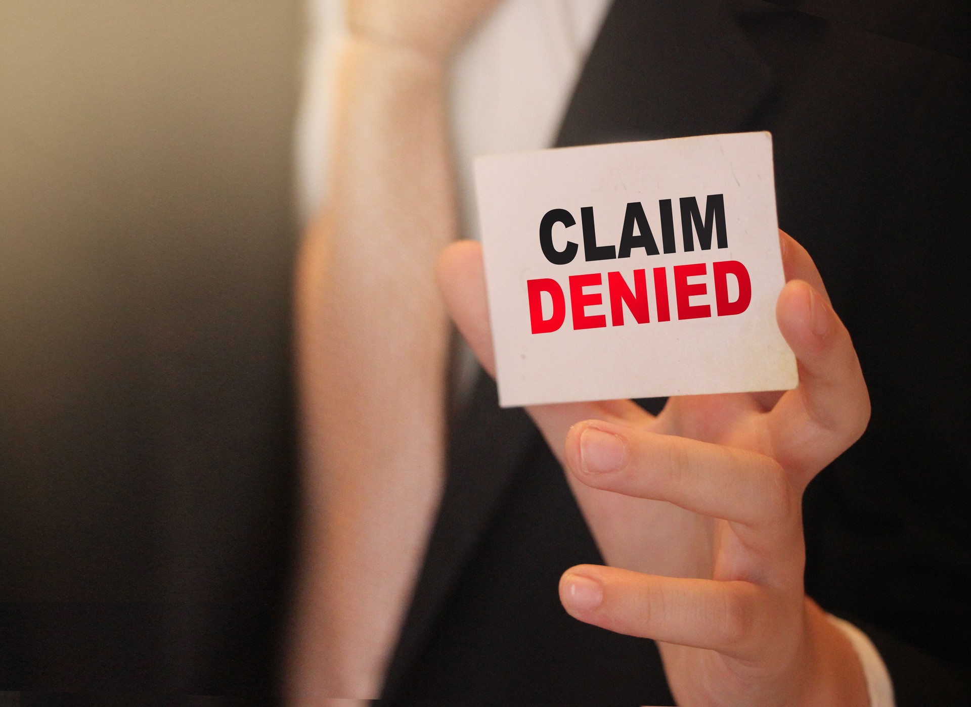 Claim Denied words on a card in hand of businessman. Business agreement termination or sponsorship project refuce concept